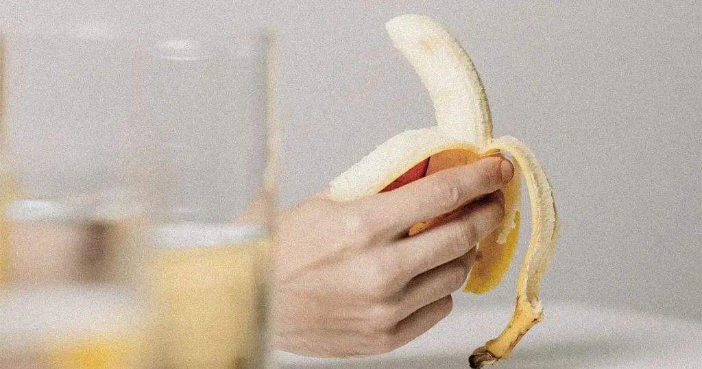 A hand holding a banana