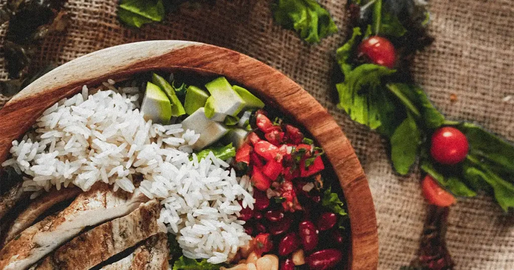 a bowl with veggies, rice and meat