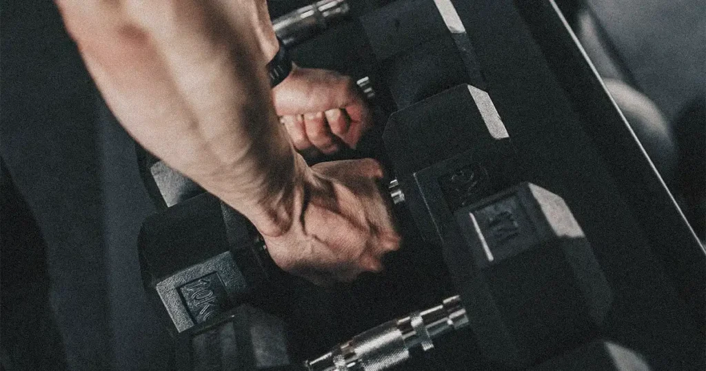 hand grabbing dumbbells