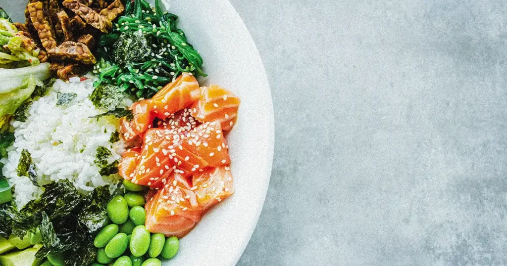 A nutritious meal with salmon, rice, and vegetable inside a bowl